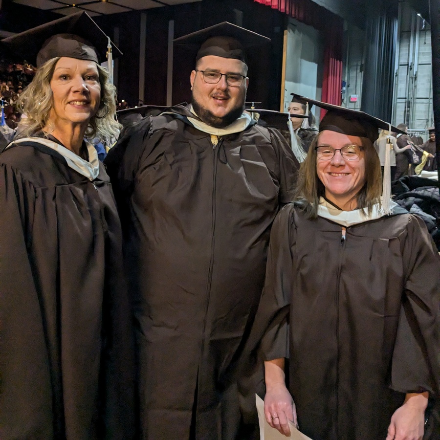 Three Western Michigan University graduates at commencement.